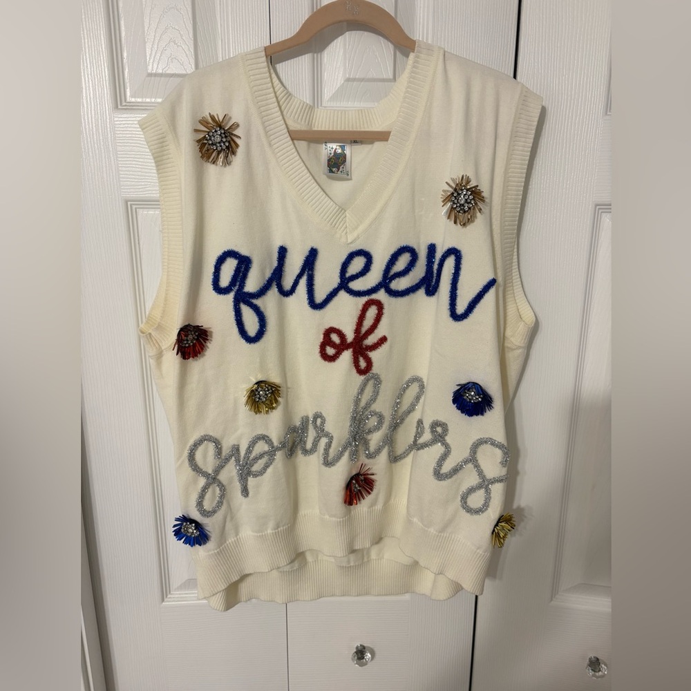 Queen of Sparkles cream, short sleeve, and jewel 
encrusted sweater.